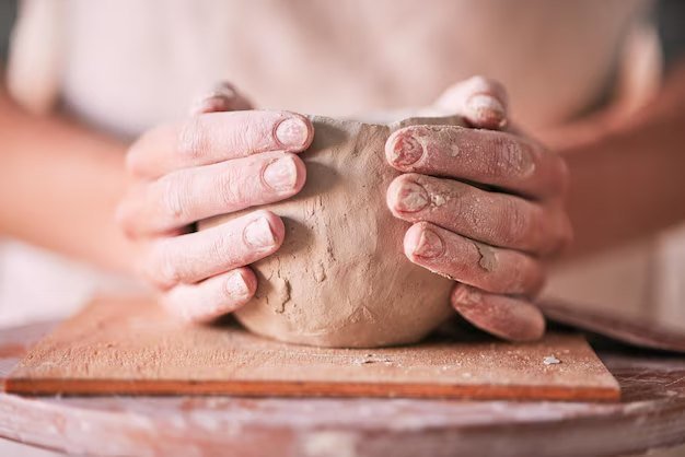 Hands shaping clay on a pottery wheel