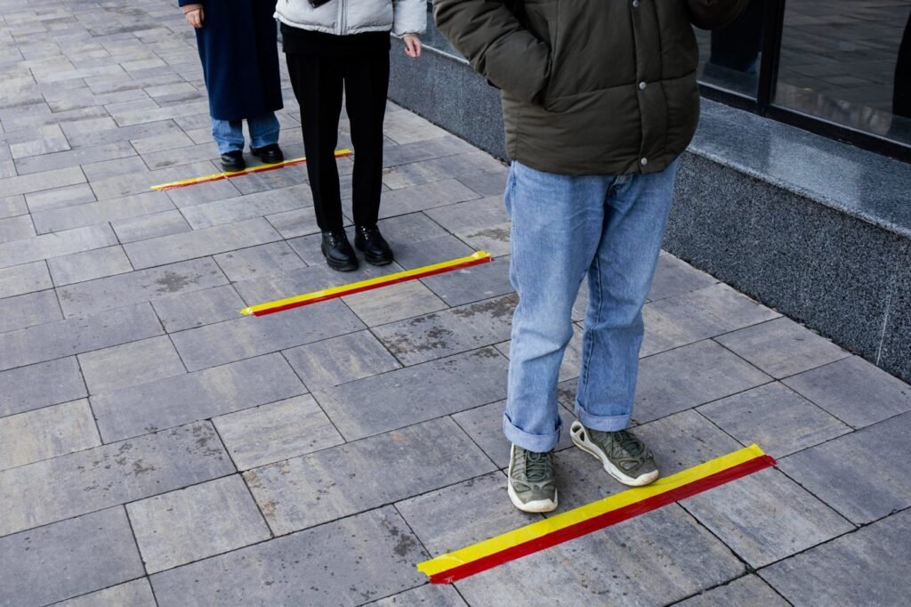 People walking along coloured tactile guide lines on a pavement